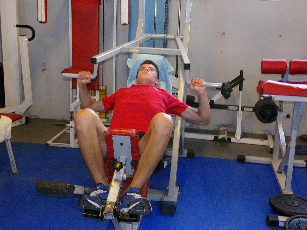 Homme installé sur le dos sur la machine de musculation servant à faire travailler le dos