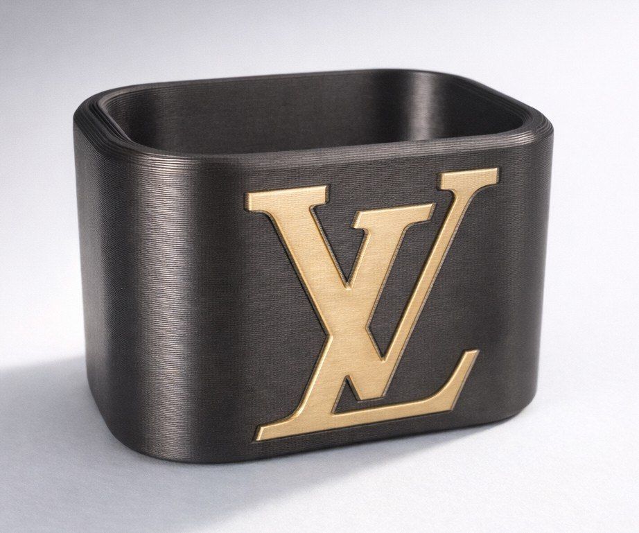 Contenitore rettangolare nero con logo Louis Vuitton dorato sul davanti.