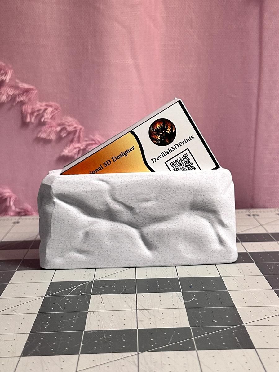 Portacarte bianco su una superficie a scacchi, con una carta arancione e bianca parzialmente visibile su sfondo rosa.