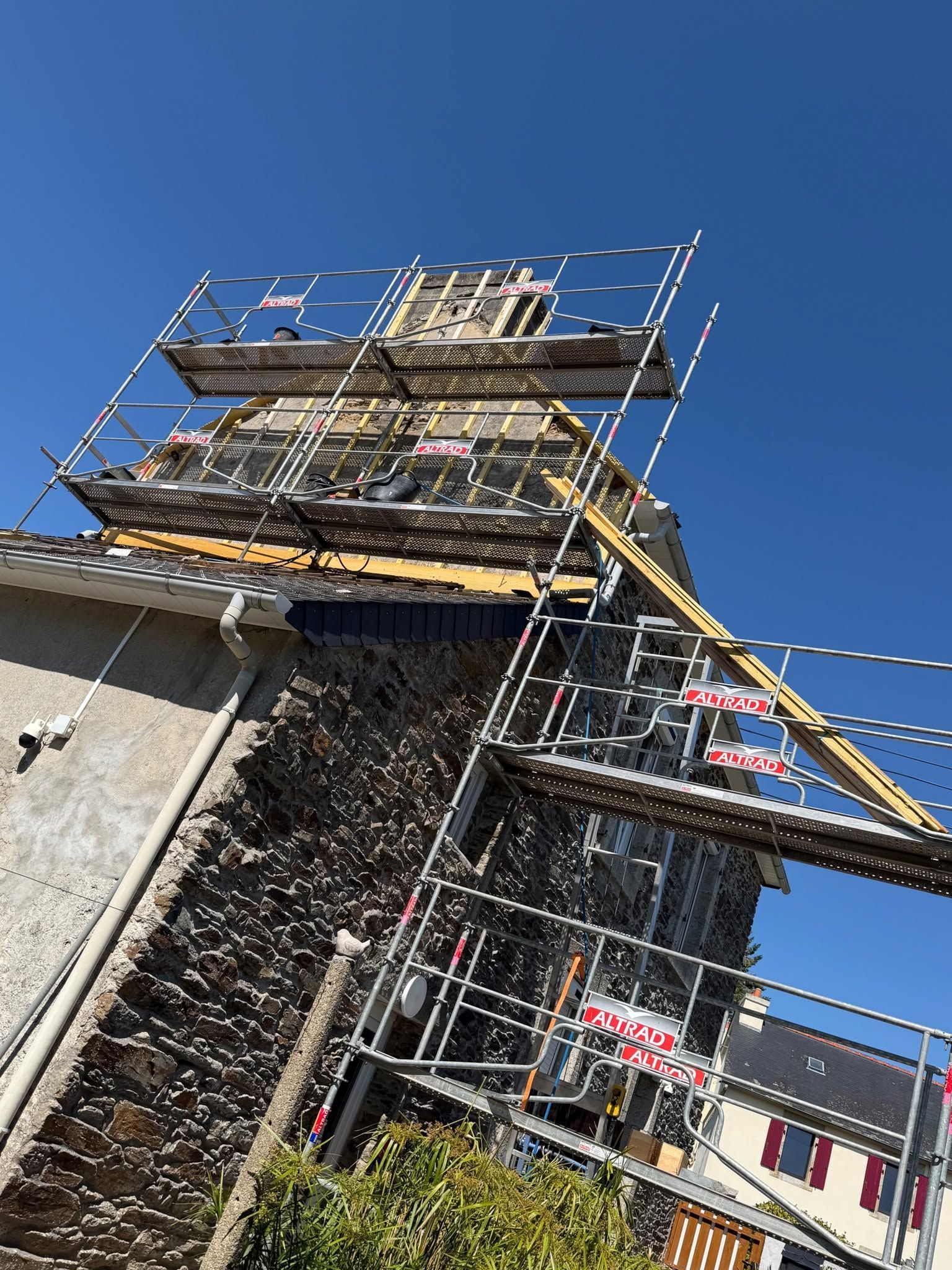 Des échafaudages entourent un bâtiment en pierre en cours de restauration.