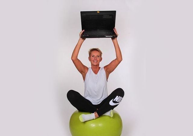 Die Physiotherapeutin der Susanne Stumpf Zentrum für ganzheitliche biologische Schmerztherapie sitzt auf einem Übungsball und hält einen Laptop