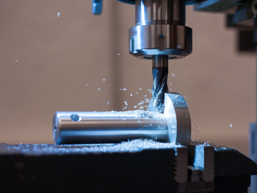 Fraiseuse CNC usinant une pièce métallique brillante, avec des étincelles qui jaillissent dans un atelier