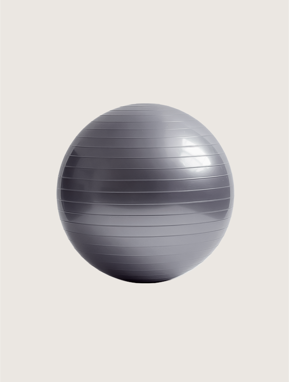 Ein grauer Gymnastikball liegt auf einer weißen Oberfläche.