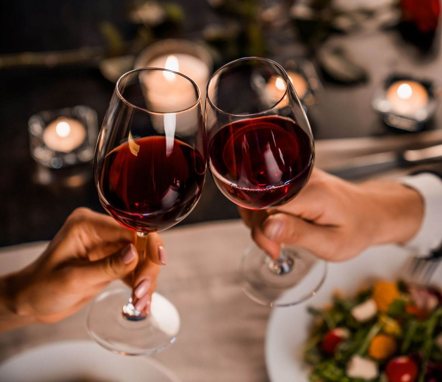 Jeune couple appréciant un verre de vin rouge au restaurant.