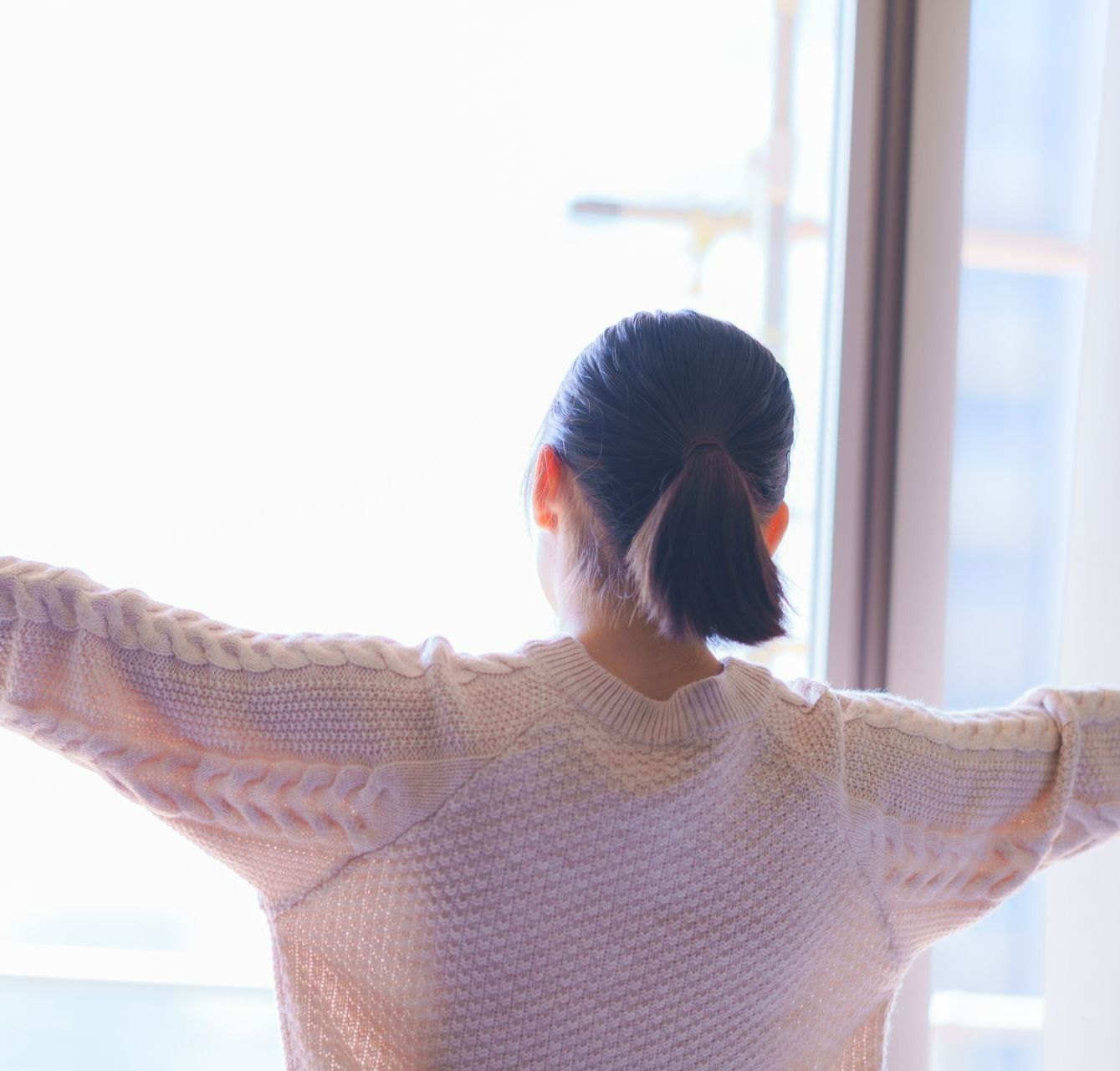 Femme ouvrant les fenêtres.