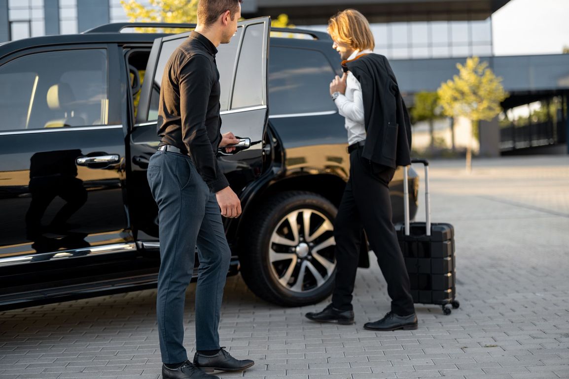 Chauffeur privé ouvrant la portière pour son client.