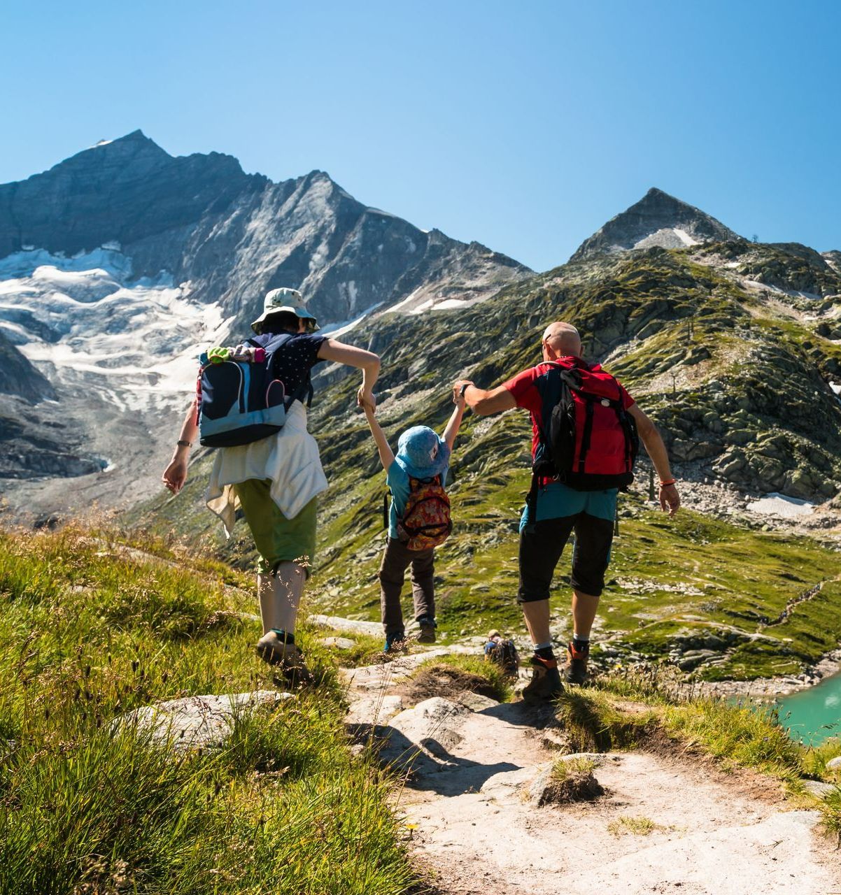 Jeune couple profitant avec leur enfant d'une randonnée dans les monts.