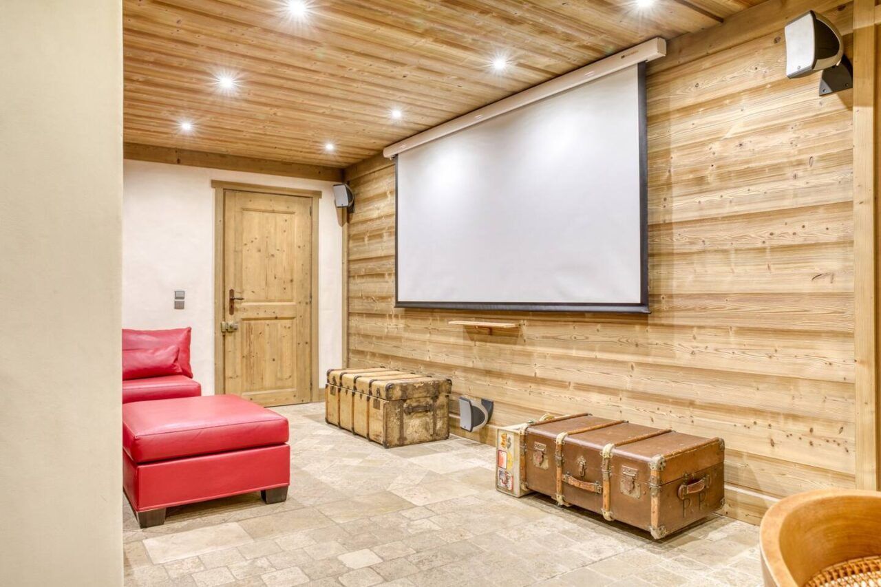 Salle de cinéma du chalet Mandarine Blanche avec toile tendue.