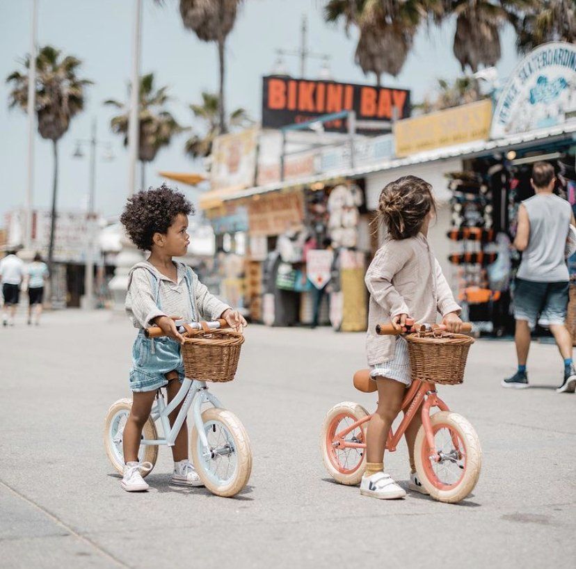 Deux enfants à vélos qui regardent des boutiques de plage