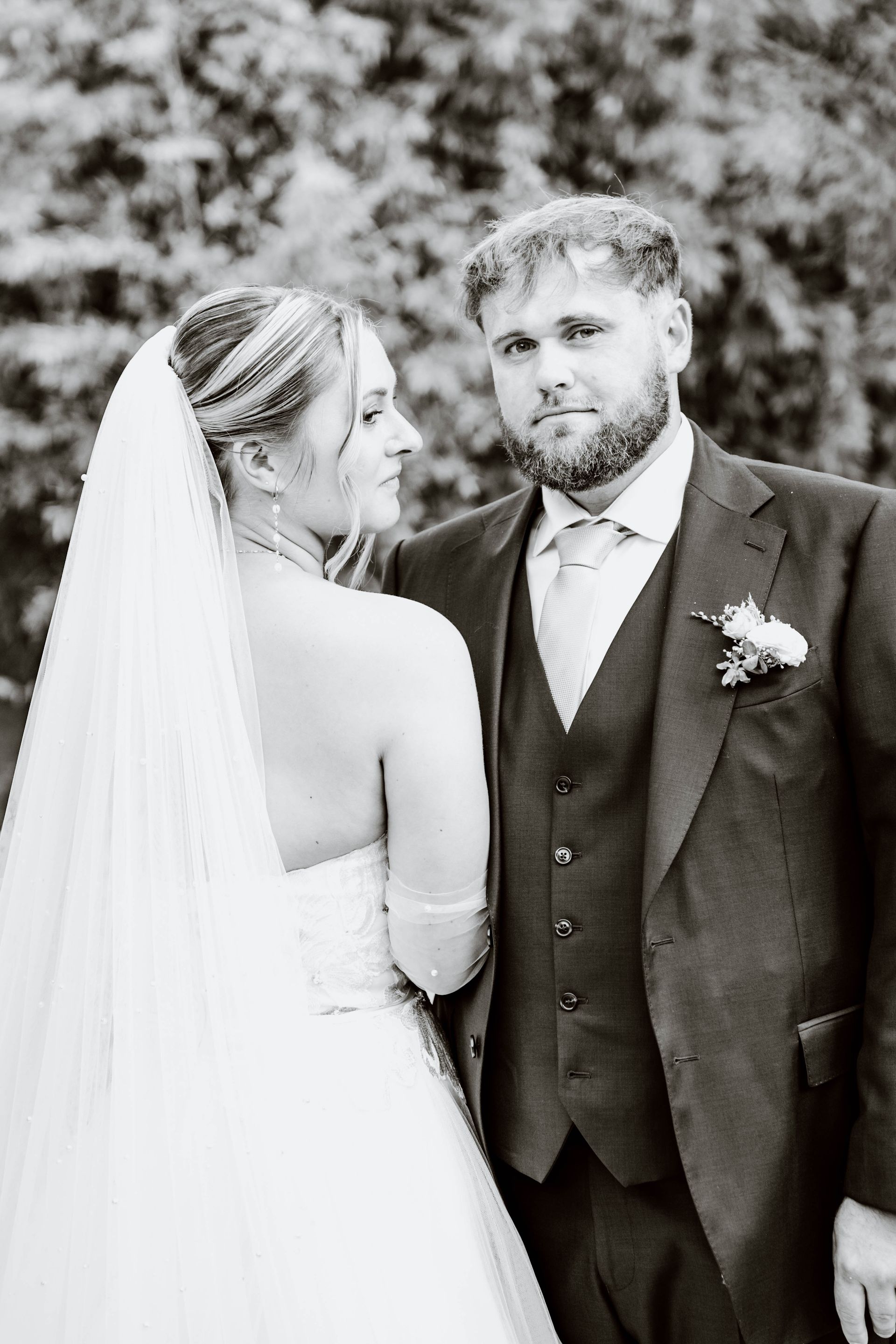 Une femme en robe blanche se tient à côté d'un homme en chemise blanche.