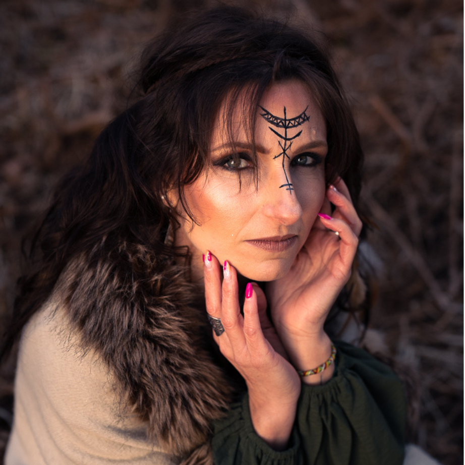 Une femme avec un tatouage sur le visage a ses mains sur son visage