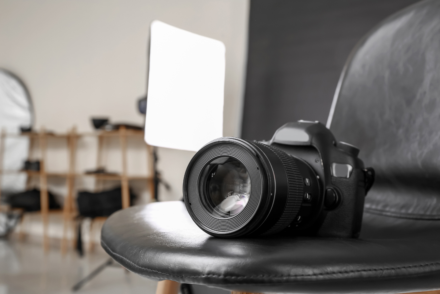 Un appareil photo est posé sur une chaise noire dans un studio photo.