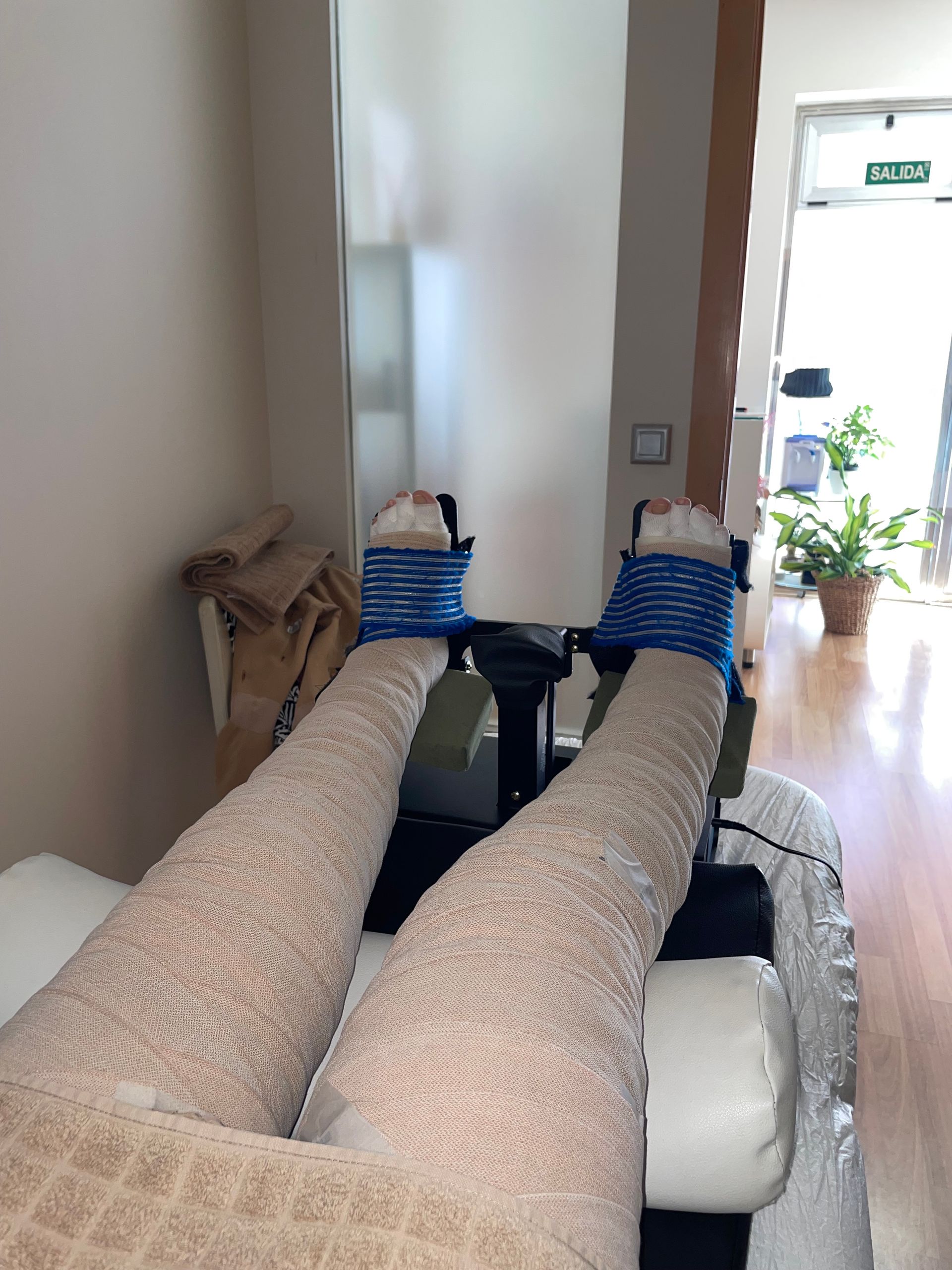 Una mujer está examinando la pierna de un hombre en una mesa.