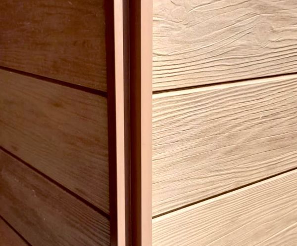 Un primer plano de una pared de madera con una moldura de metal.