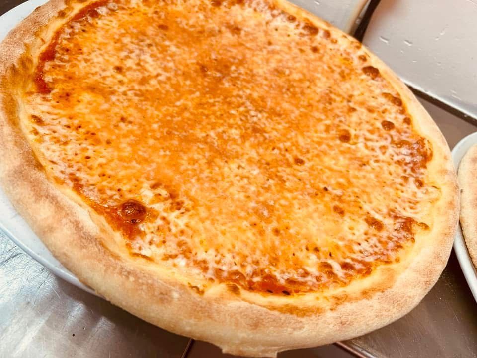 Zwei Pizzen liegen auf Tellern auf einem Tisch.