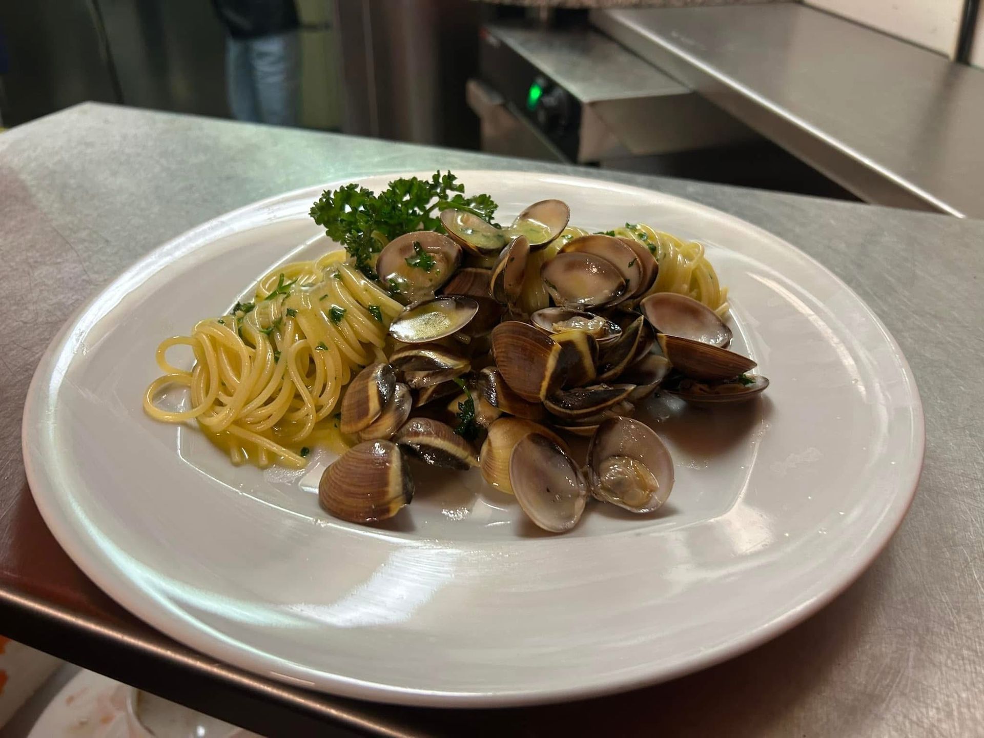 Eine Flasche Wein und ein Glas Wein stehen neben einer Pizza auf einem Tisch.