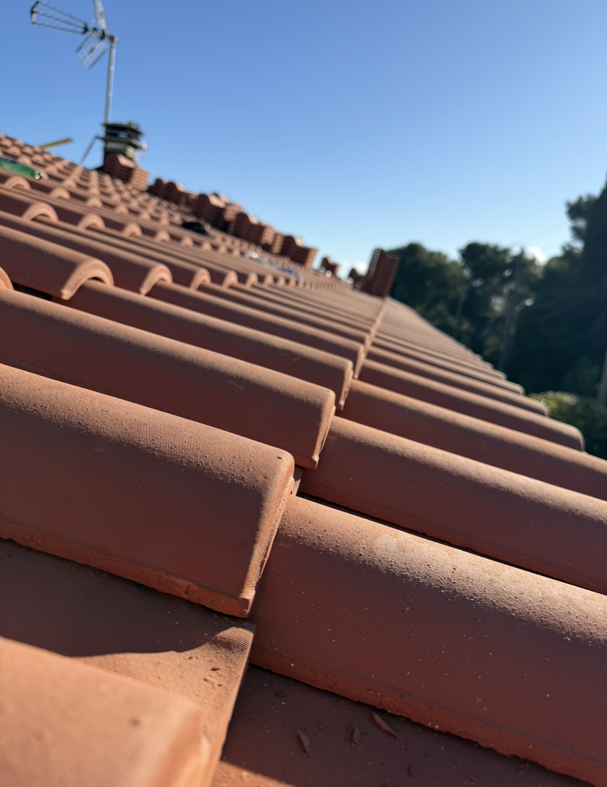 Toit de tuiles sous un ciel bleu éclatant et ensoleillé.