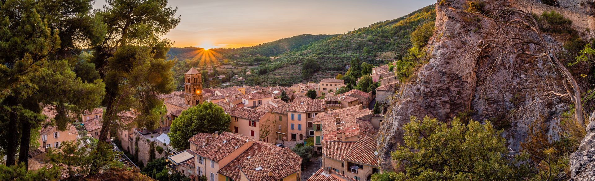 Vue panoramique d'un village méditerranéen aux maisons aux toits de tuiles rouges et coucher du soleil.
