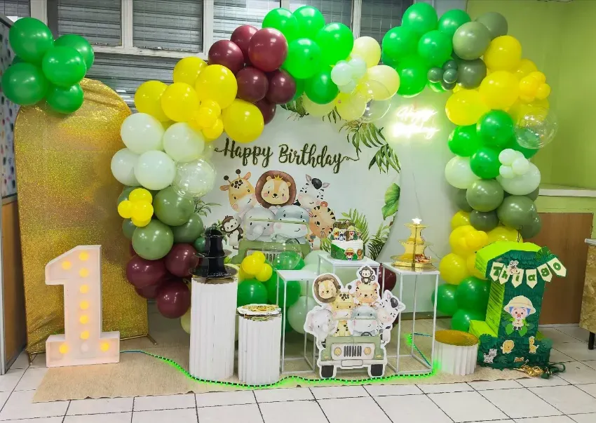 Fondo para fiesta de cumpleaños con globos verdes, amarillos y burdeos, un número 1 iluminado y cajas de regalo.