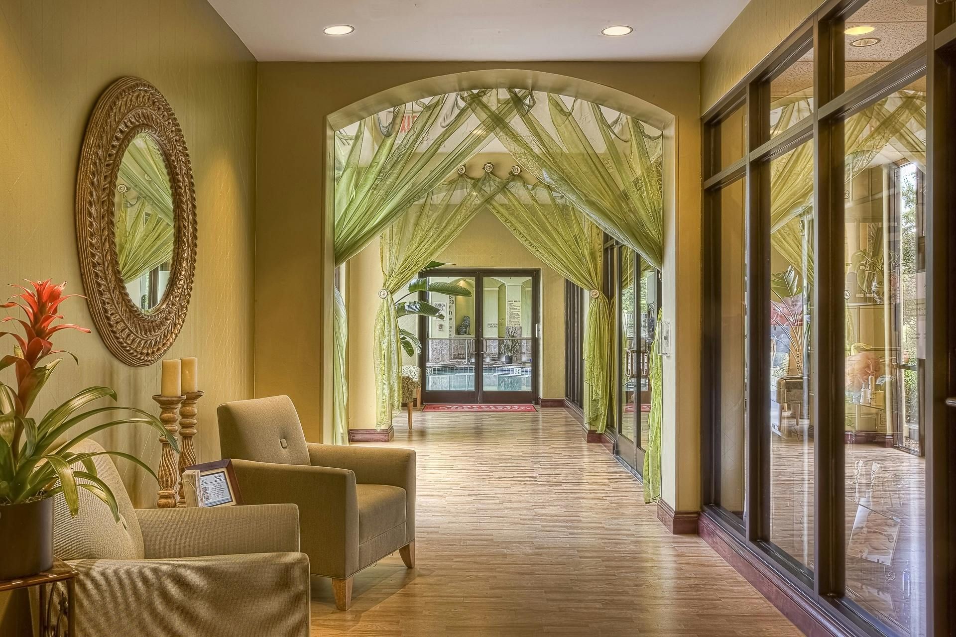 A hallway with chairs and a mirror on the wall