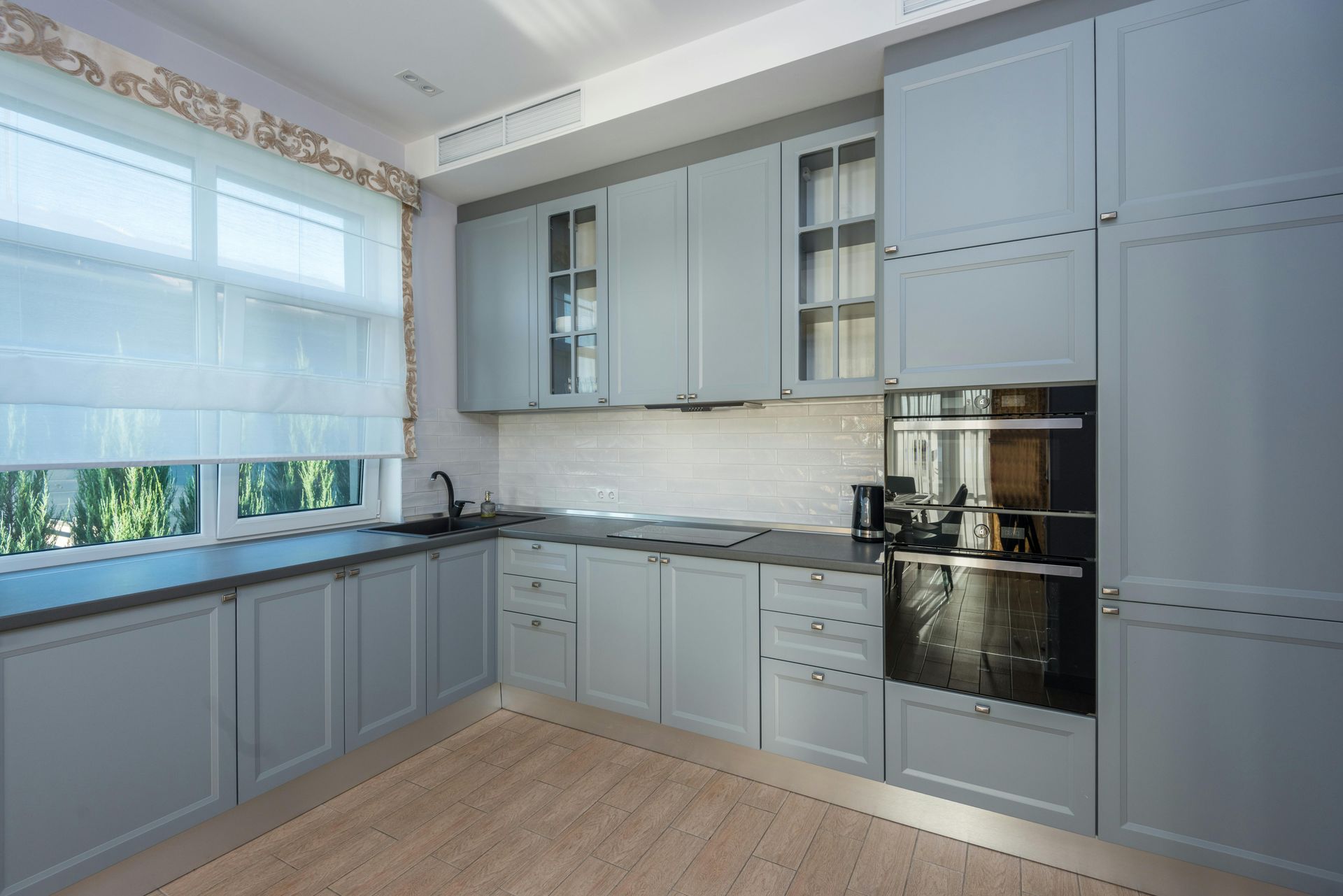 A kitchen with a lot of cabinets and a window.