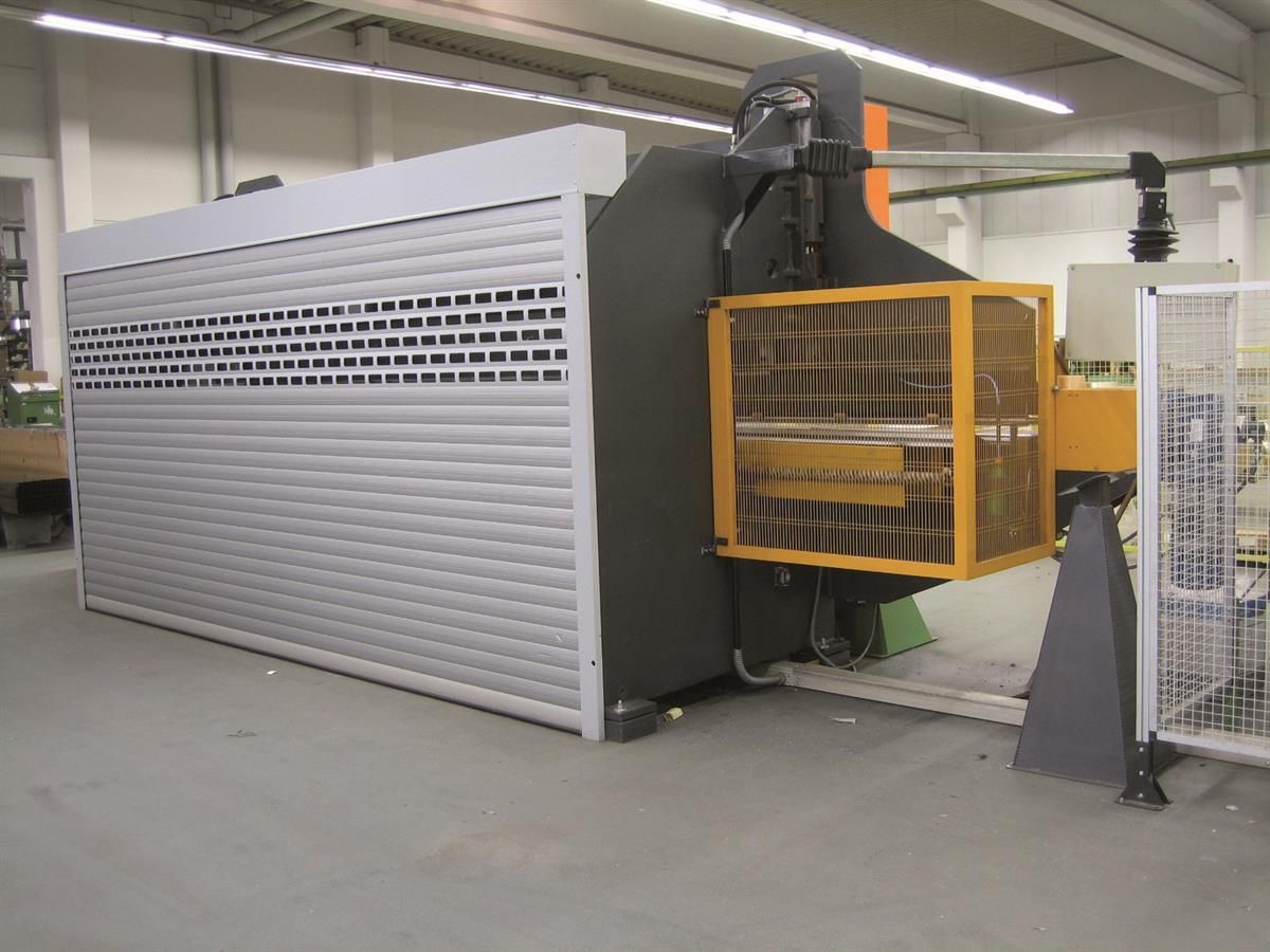 Eine Maschine in einer Fabrik mit einem gelben Käfig darum herum