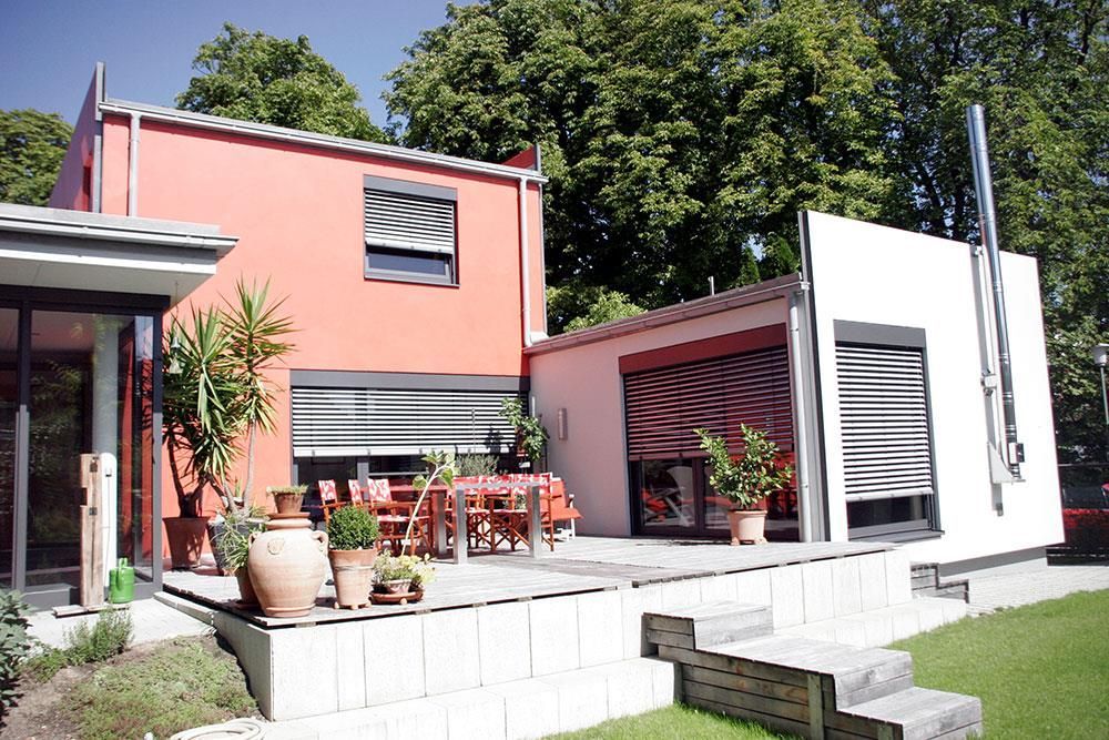 Ein rot-weißes Haus mit einer Terrasse davor