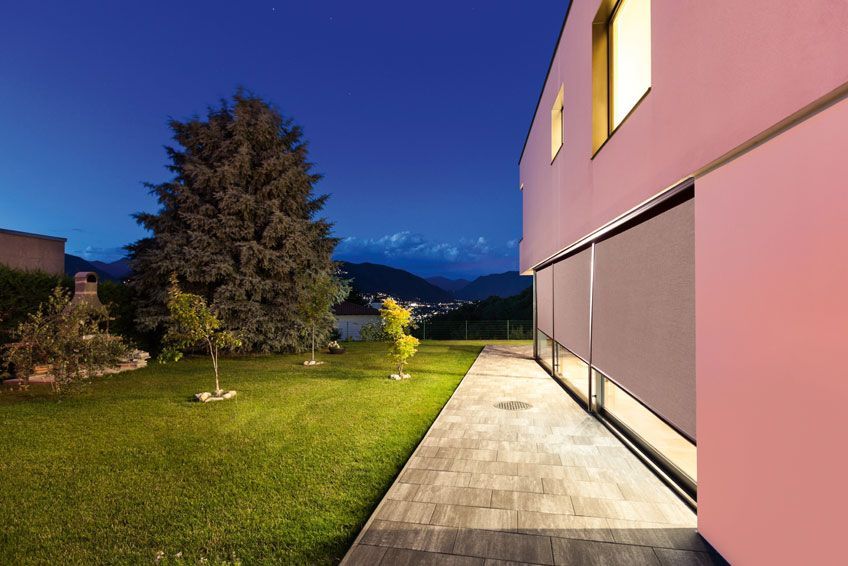 Ein rosa Haus mit einer Terrasse und Bergen im Hintergrund