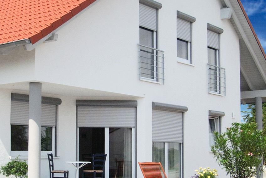 Ein weißes Haus mit rotem Dach und Fensterläden