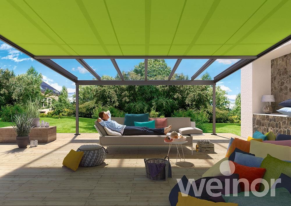 Ein Mann liegt auf einer Couch unter einer Markise von Weinor