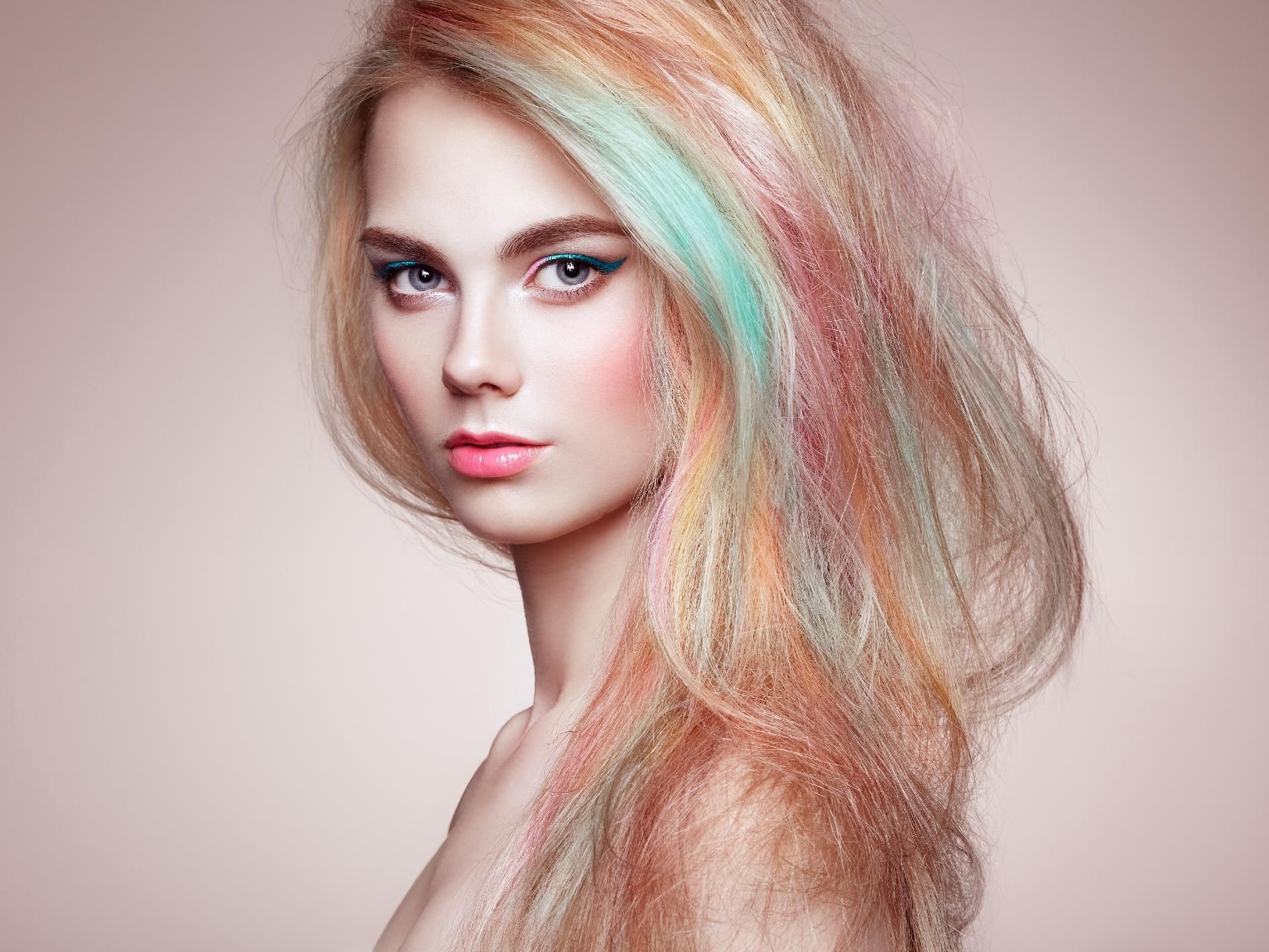 Ein Model mit schulterlangem, mehrfarbigem Pastellhaar in Mint-, Pfirsich- und Blondtönen im Friseursalon Kagel in Werder.