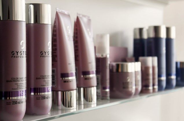 Ein Regal voller Rosa und Lila Haarpflegeprodukte mit silbernem Logo im Friseursalon Meyer & Marks by Anja Kagel in Werder.