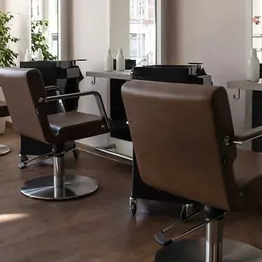Zwei braune Friseurstühle vor Spiegeln im Friseursalon Meyer & Marks by Anja Kagel in Werder.