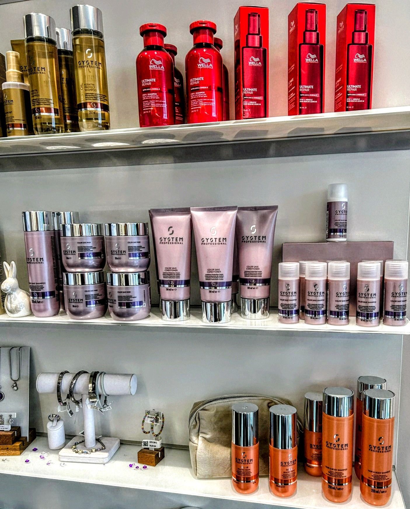 Im Salon Kagel stehen Regale mit verschiedenen Haarpflegeprodukten in Flaschen, Tuben und Behältern sowie ein Schmuckständer.