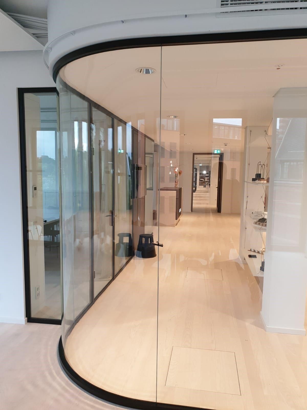 Ein Flur in einem Gebäude mit einer gebogenen Glaswand