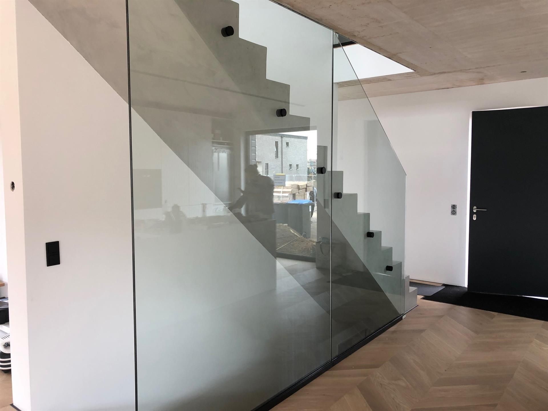 Eine Treppe mit einem Glasgeländer in einem Haus