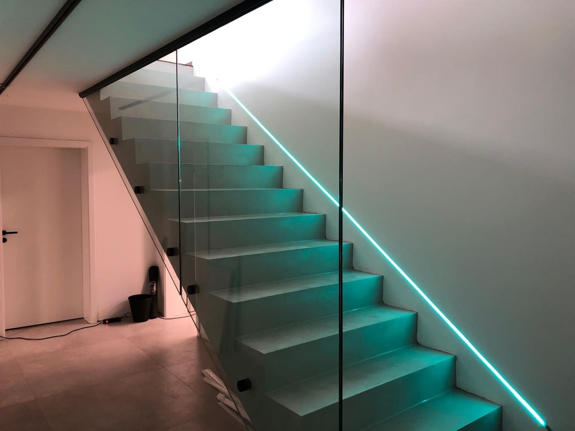 Eine Treppe mit einem grünen Licht am Geländer
