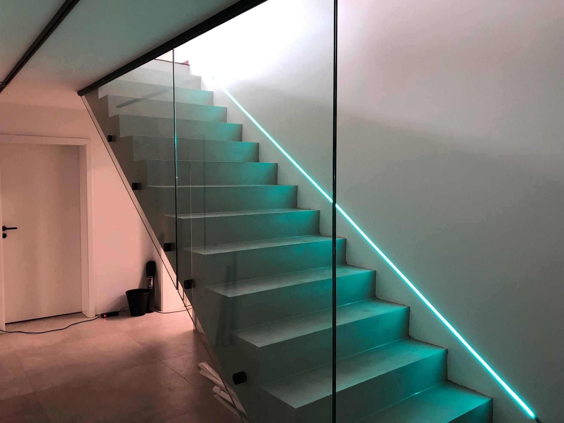 Eine Treppe mit einem grünen Licht am Geländer