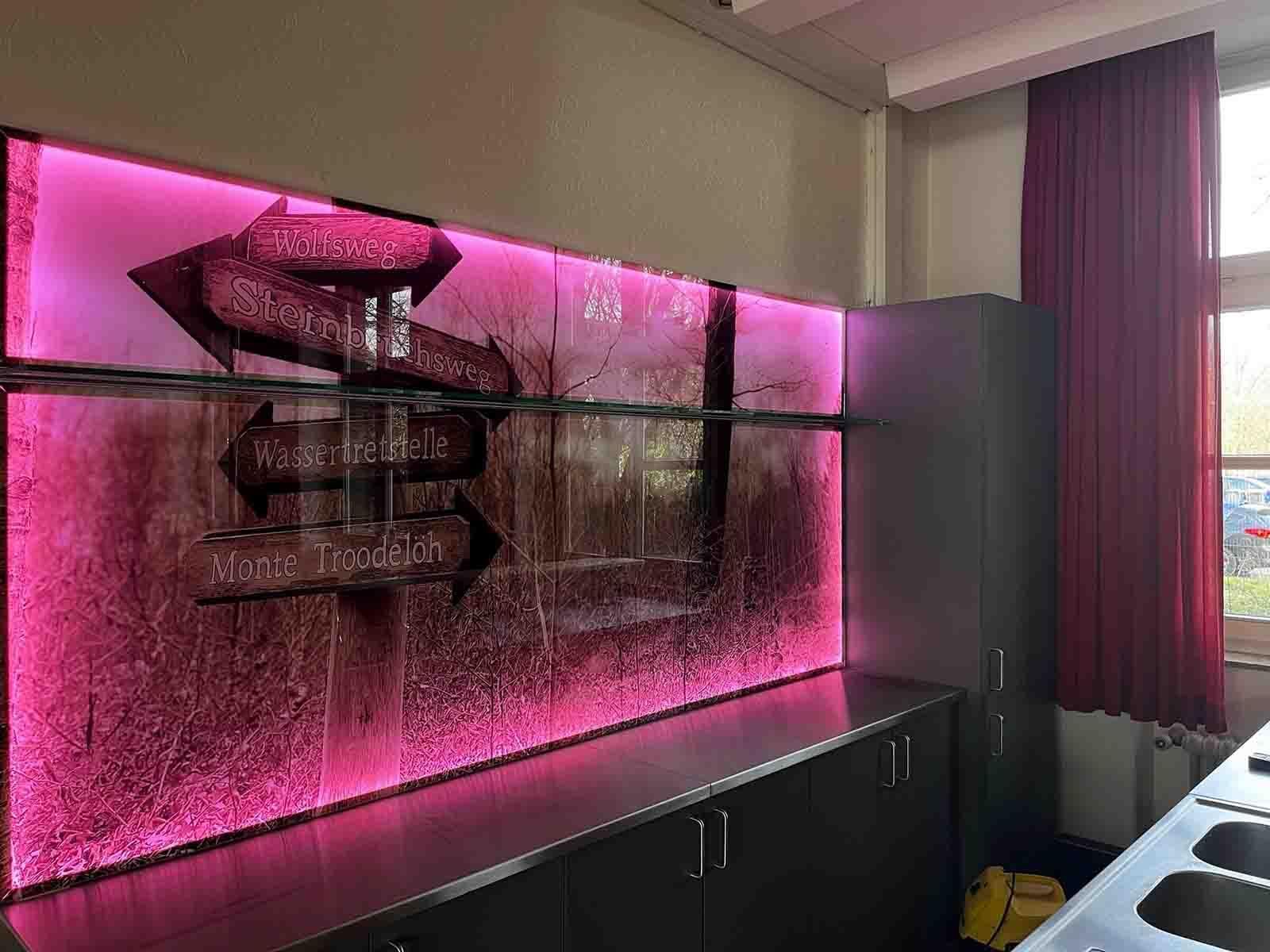 Eine Küche mit einer rosa Wand mit Pfeilen darauf