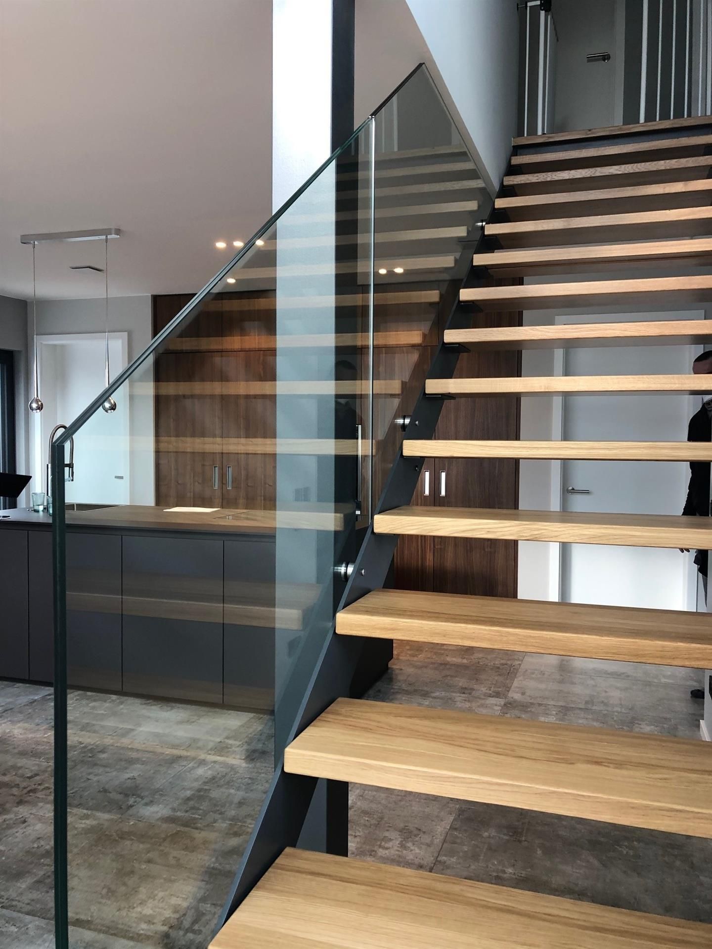 Eine Treppe mit Holzstufen und einem Glasgeländer