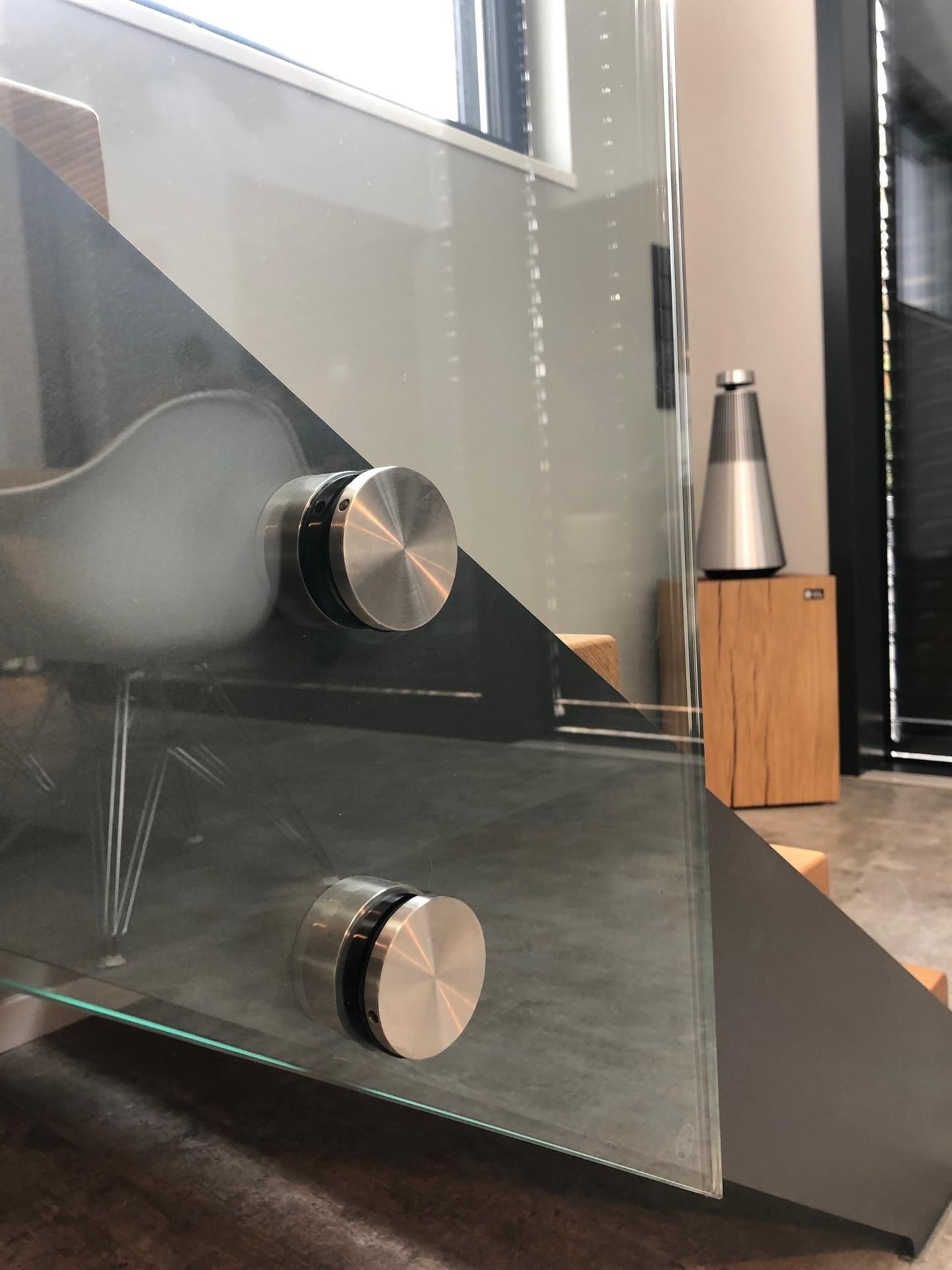 Eine Treppe mit Glasgeländer in einem Wohnzimmer