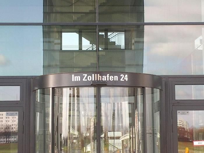 Ein Gebäude mit einer Drehtür, auf der steht: „Im Zollhafen 24“