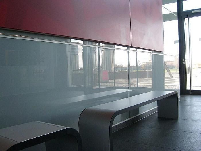 Eine Reihe von Bänken vor einer Glaswand