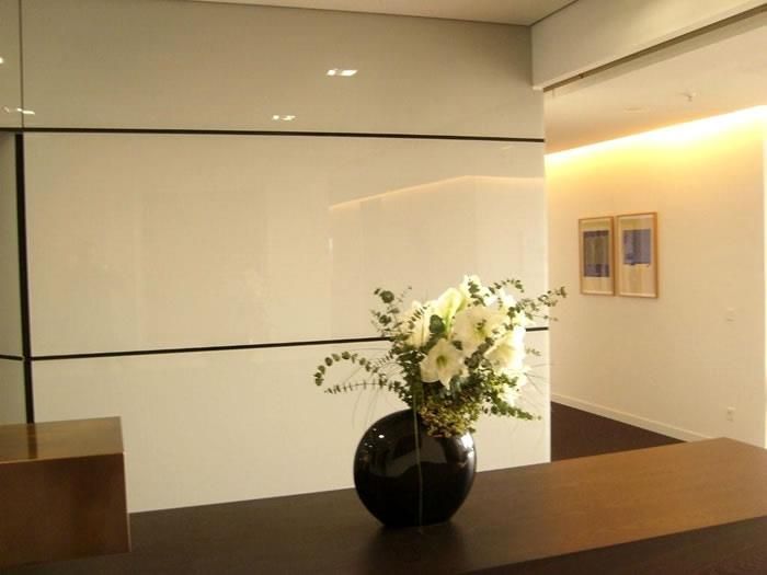 Eine schwarze Vase mit weißen Blumen gefüllt steht auf einem Tisch