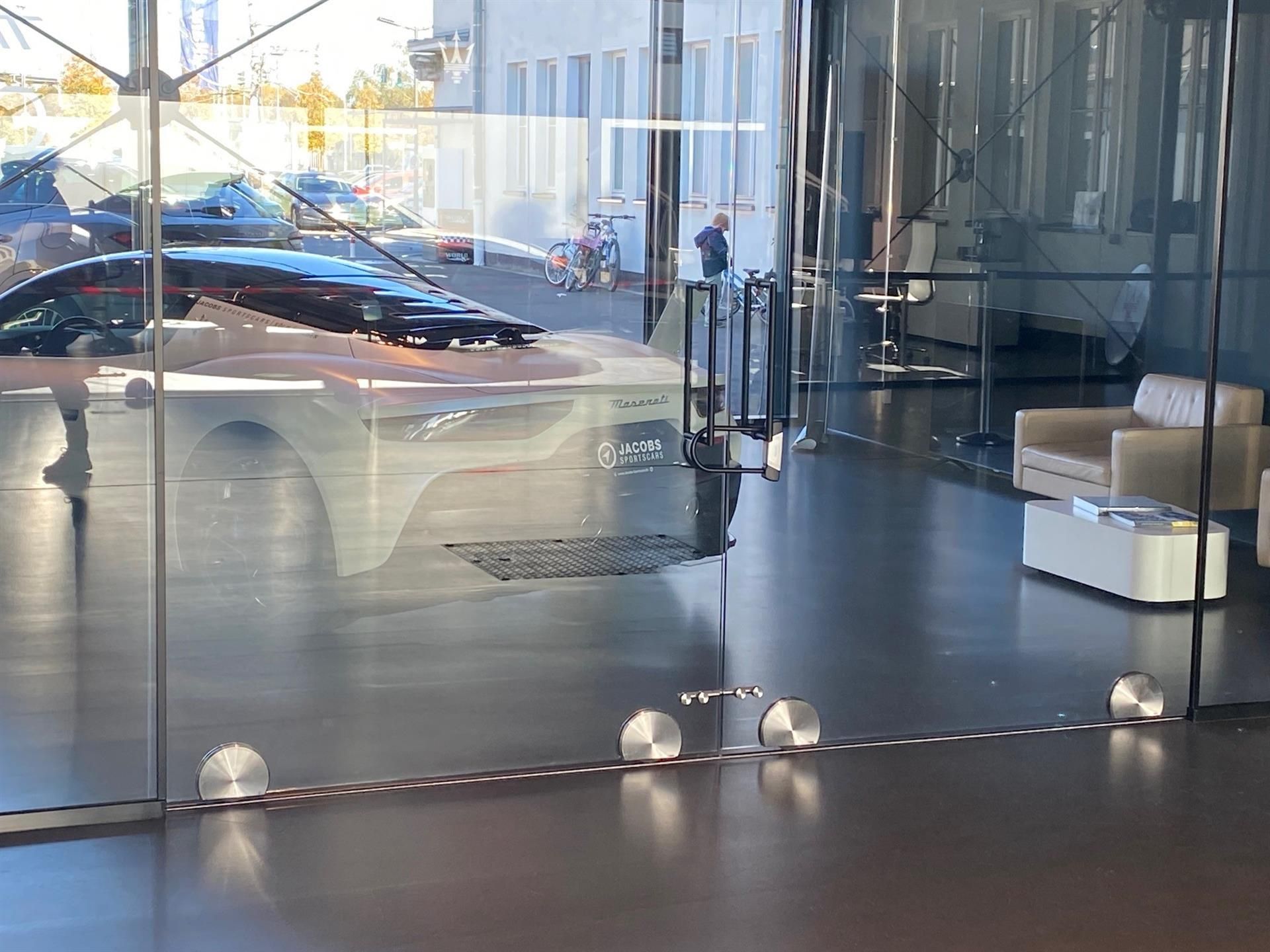 Eine Reihe von Autos sind hinter einer Glaswand geparkt