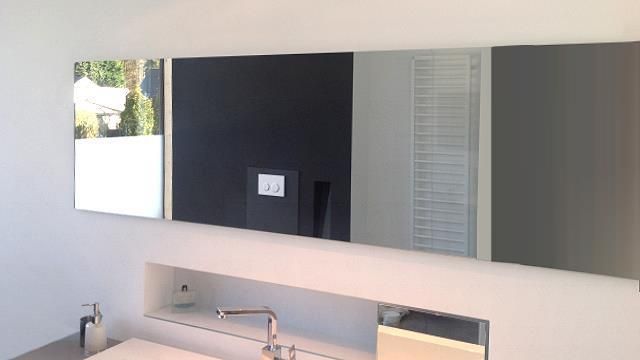 Ein Badezimmer mit drei Spiegeln und einem Waschbecken