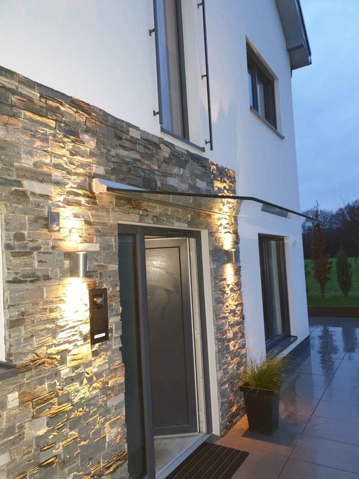 Die Haustür eines Hauses ist nachts beleuchtet