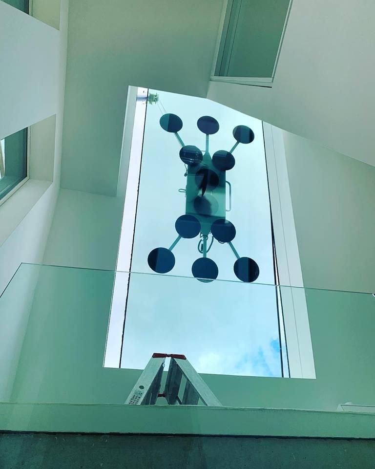 Eine Treppe mit einem Glasgeländer und der Spiegelung eines Moleküls im Glas