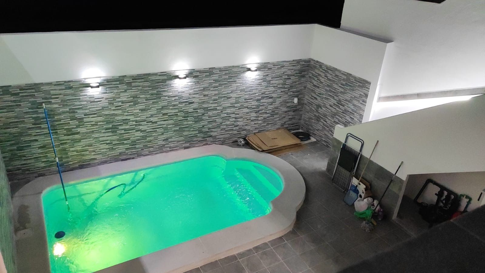 Una vista aérea de una piscina iluminada por la noche.