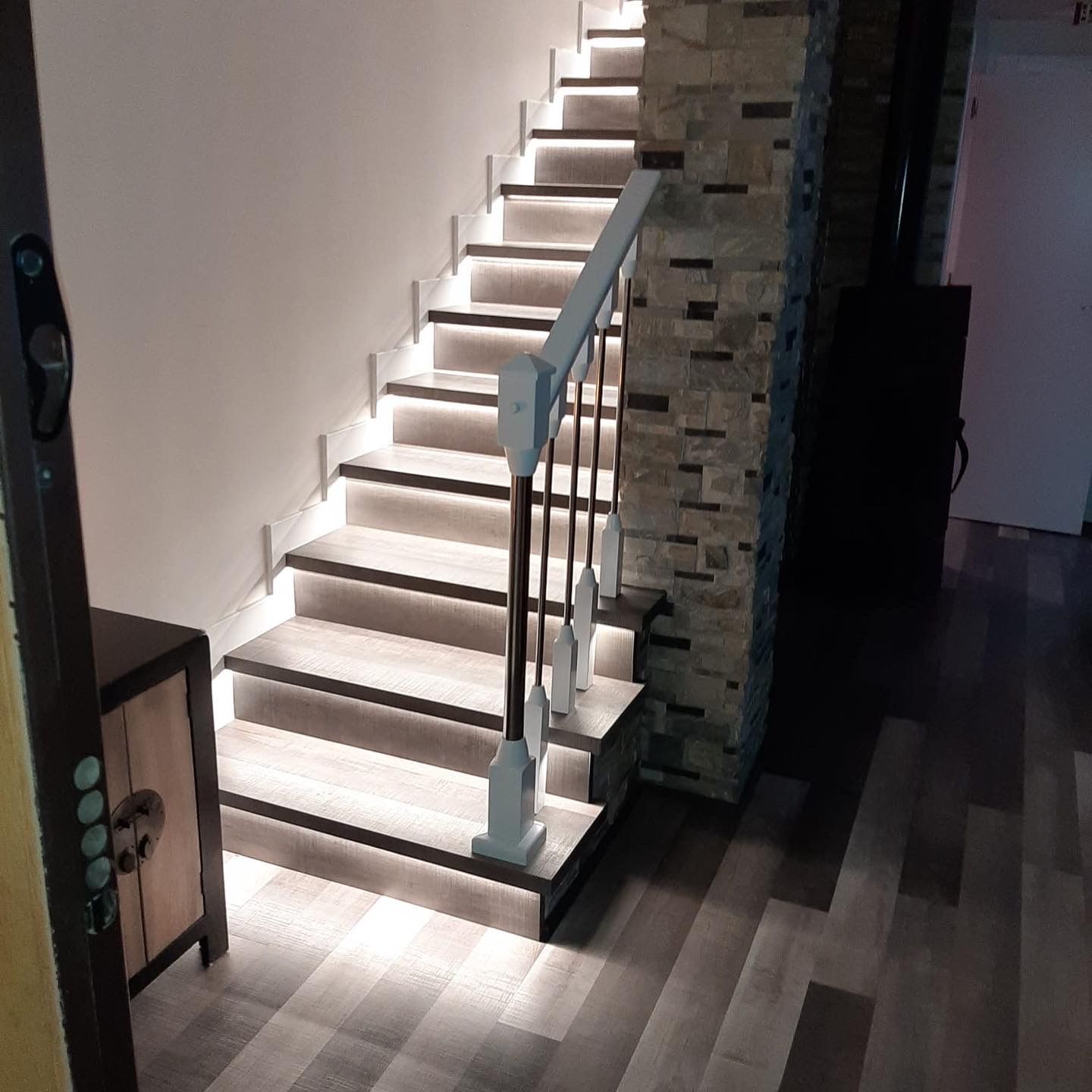 Una escalera con luces en los escalones de un pasillo.